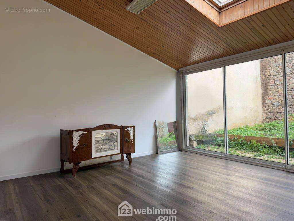 Un salon baigné de lumière donnant dans le jardin. - Maison à POUZAUGES