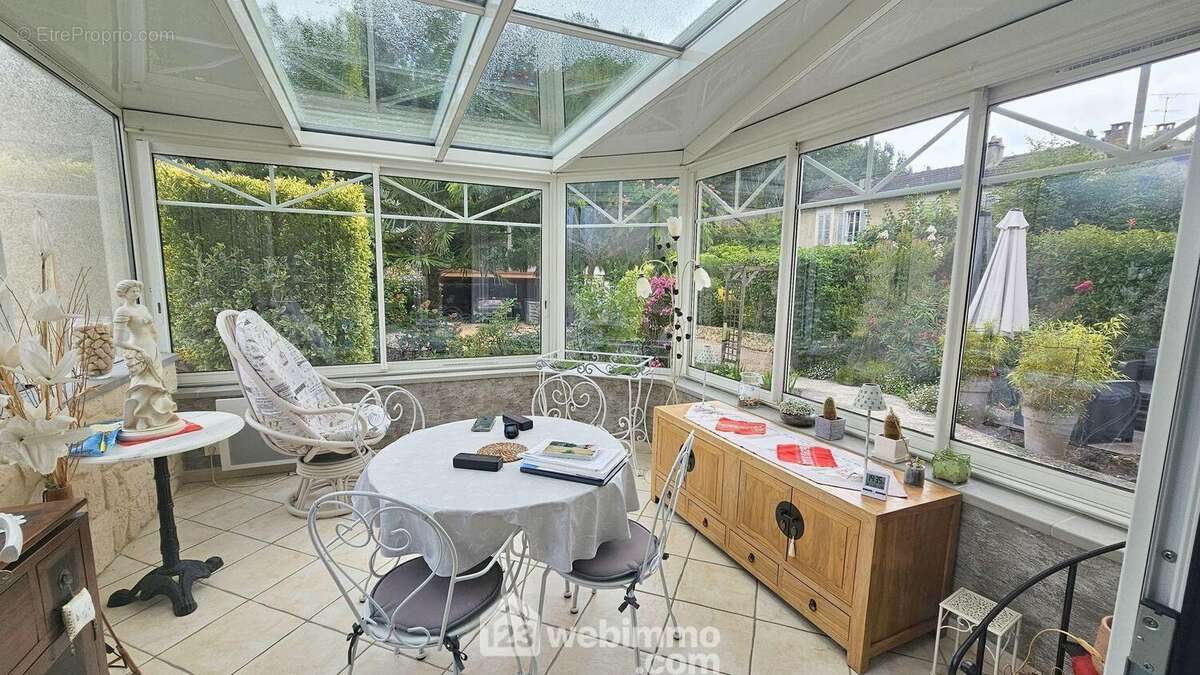 Une magnifique véranda de 12 m² avec une vue sur le jardin arboré. - Maison à SAINT-FARGEAU-PONTHIERRY