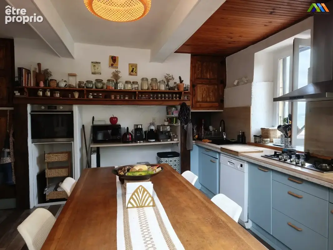 Cuisine équipée avec poutres apparentes et espace repas convivial