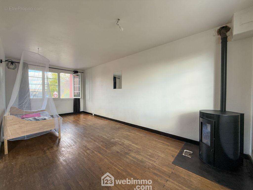 Un salon- séjour de 20 m² avec parquet massif et un poêle à granulés, - Maison à LA CHATAIGNERAIE