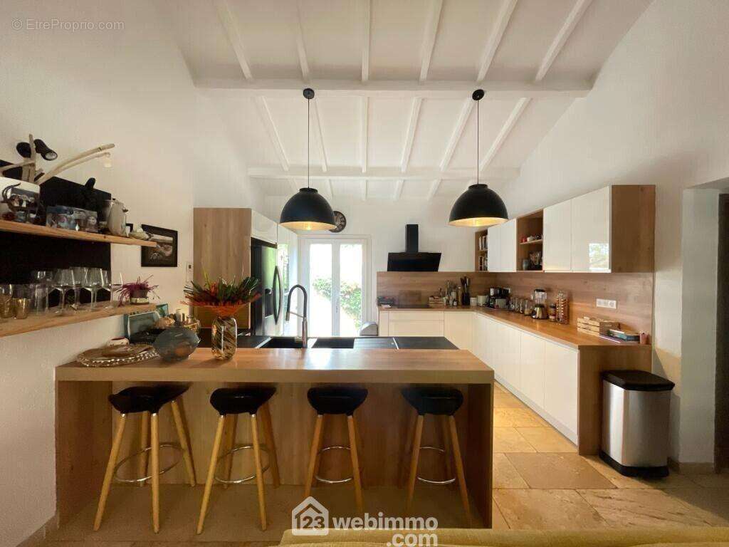 Une cuisine entièrement équipée, conviviale et ouverte sur les espaces de réception.