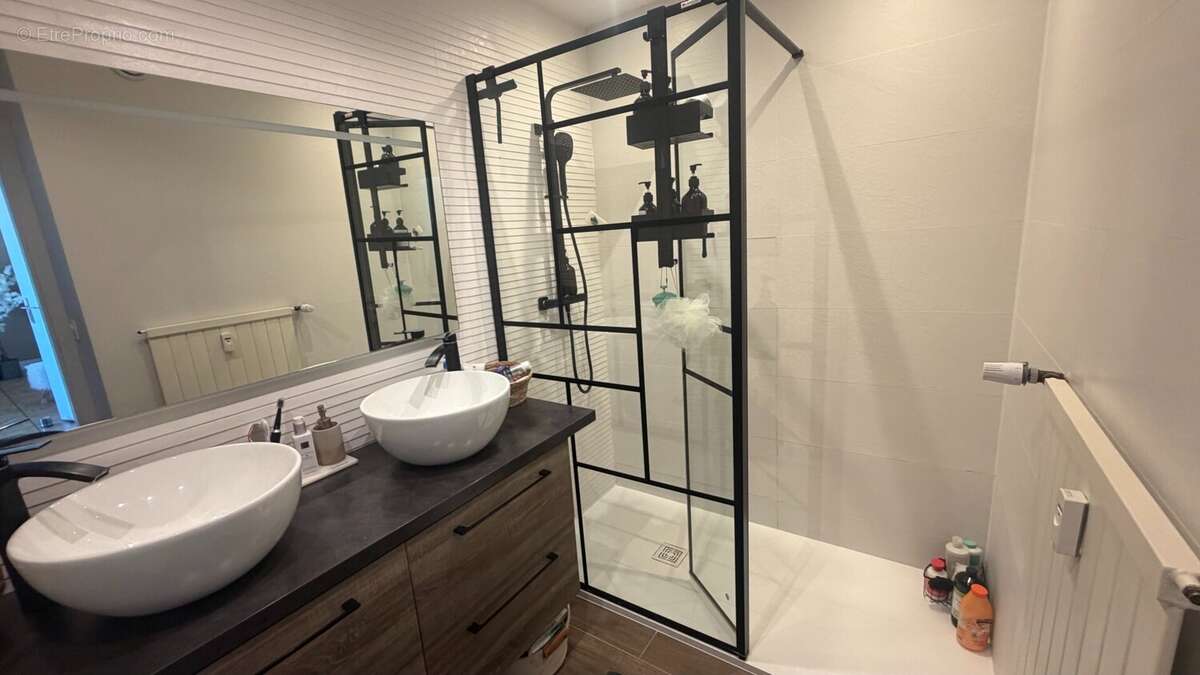 Salle de bains moderne avec douche et meuble double vasque. - Appartement à ANNEMASSE