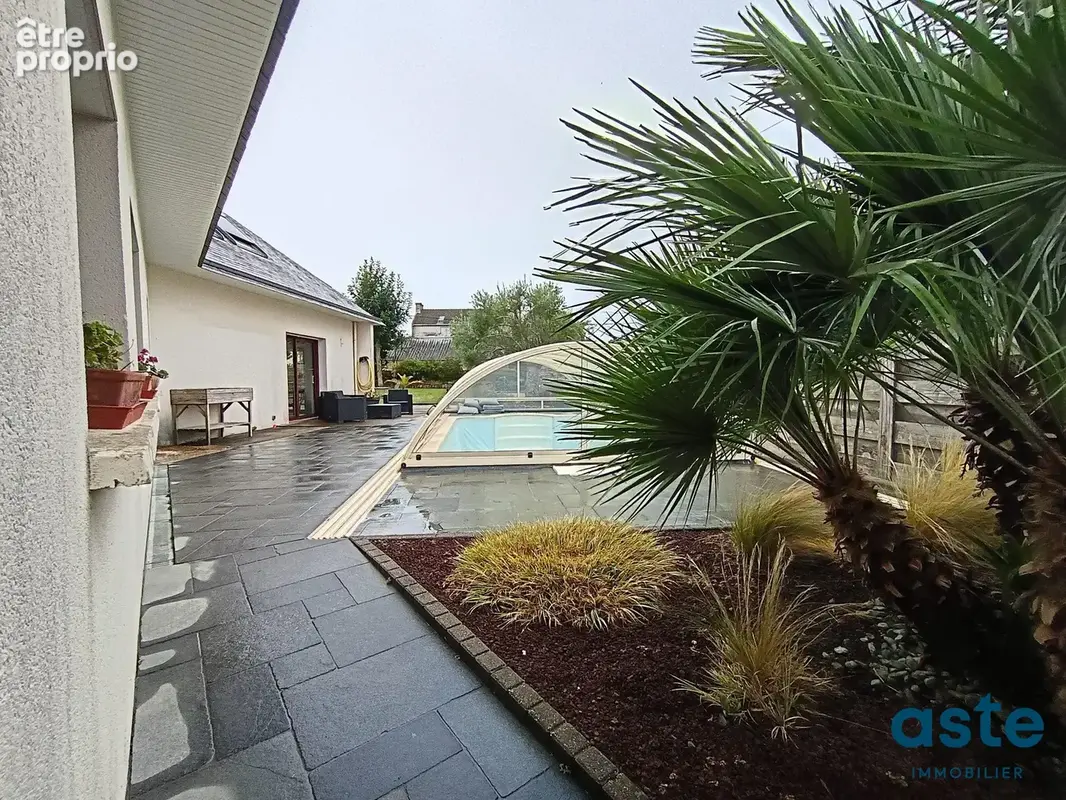 Vue extérieure arrière : La façade Sud/Ouest donnant sur la terrasse en bois, la piscine et le jardin