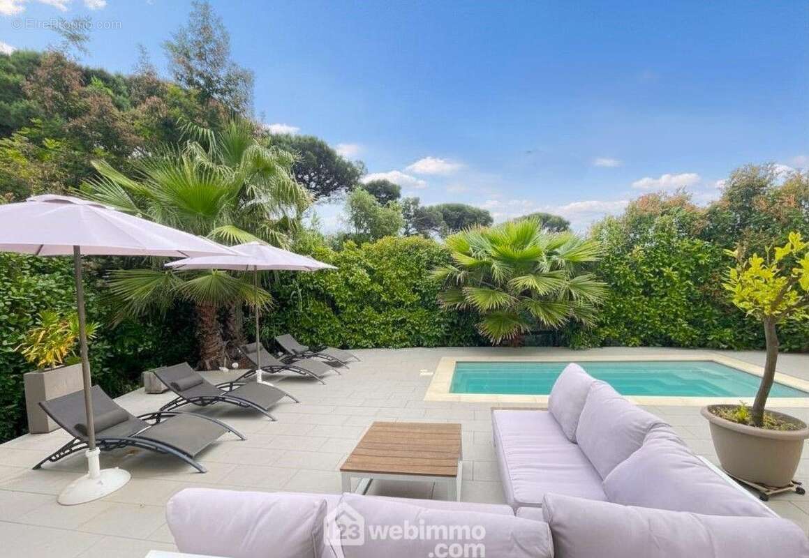 Une vue privilégiée sur l?espace piscine, entre palmiers et ciel azur. - Maison à SAINTE-MAXIME