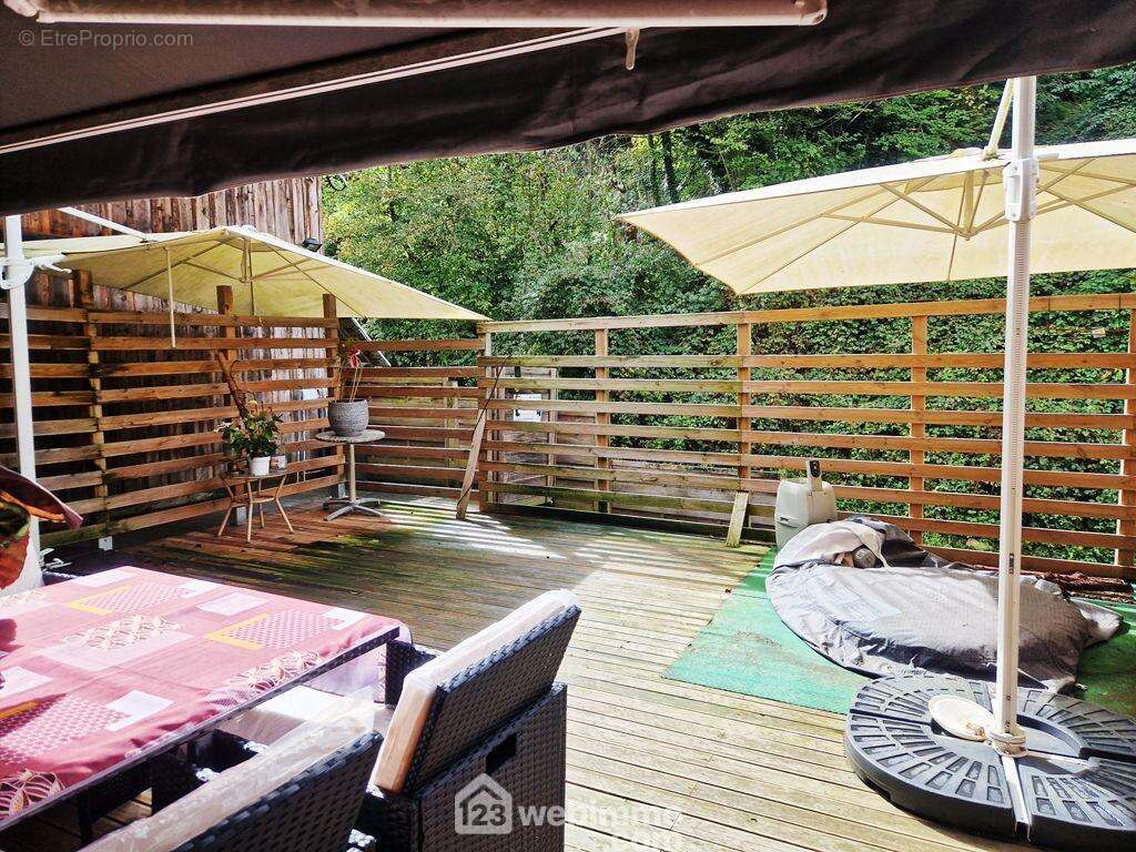 Elle donne accès à une terrasse de 45m² exposée Sud-Ouest. - Maison à VENTHON