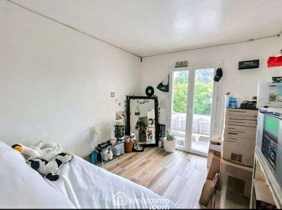 Chambre confortable ouverte sur un cadre verdoyant avec piscine en arrière-plan. - Maison à SAINTE-MAXIME