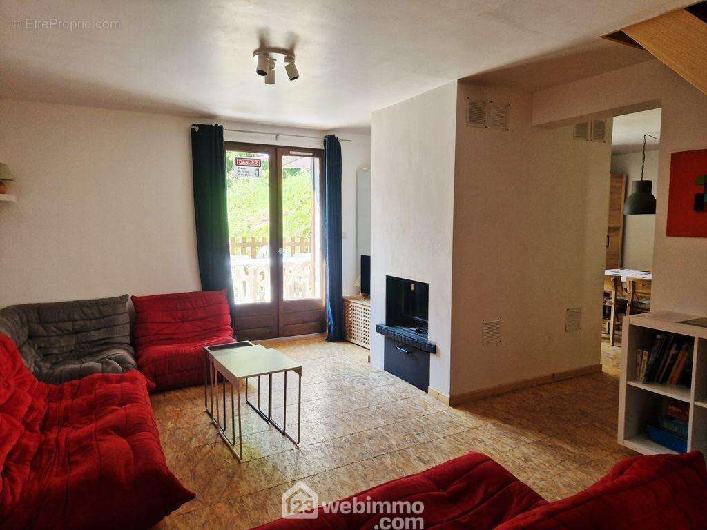 Son salon cosy avec un deuxième insert bois permet également d&#039;accéder à ses extérieurs. - Maison à LA LECHERE