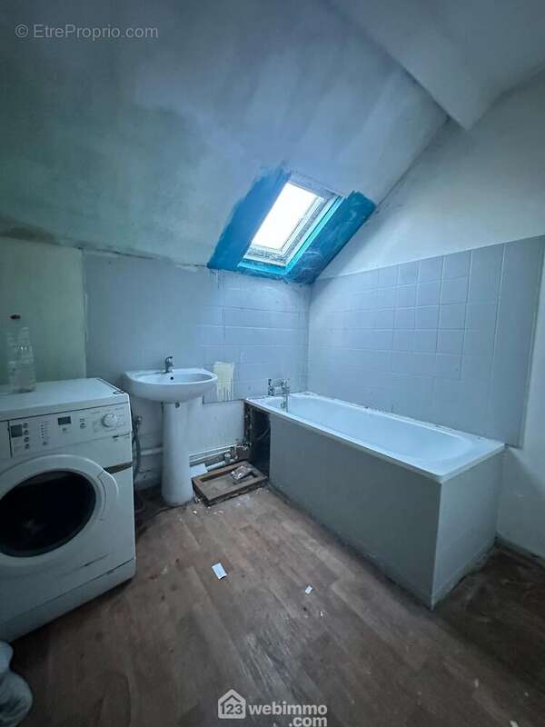 La salle de bains avec lavabo et une baignoire