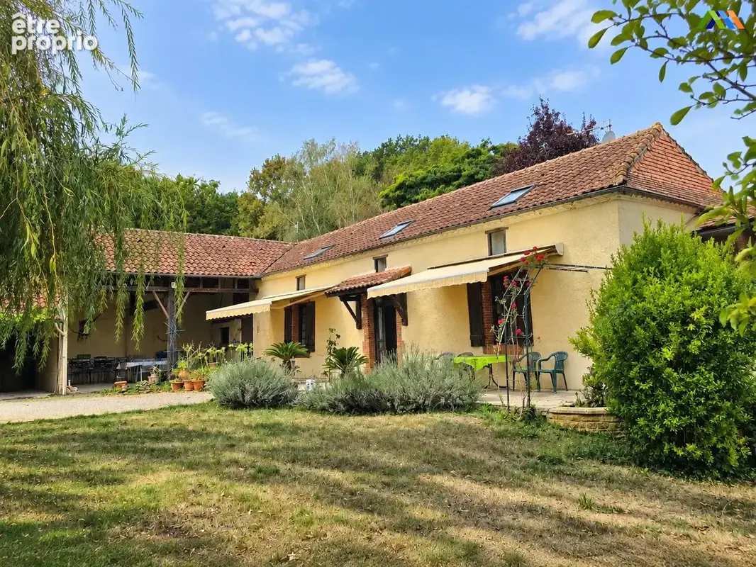 Maison traditionnelle dans le Gers, avec toiture en tuiles, stores et terrasse.