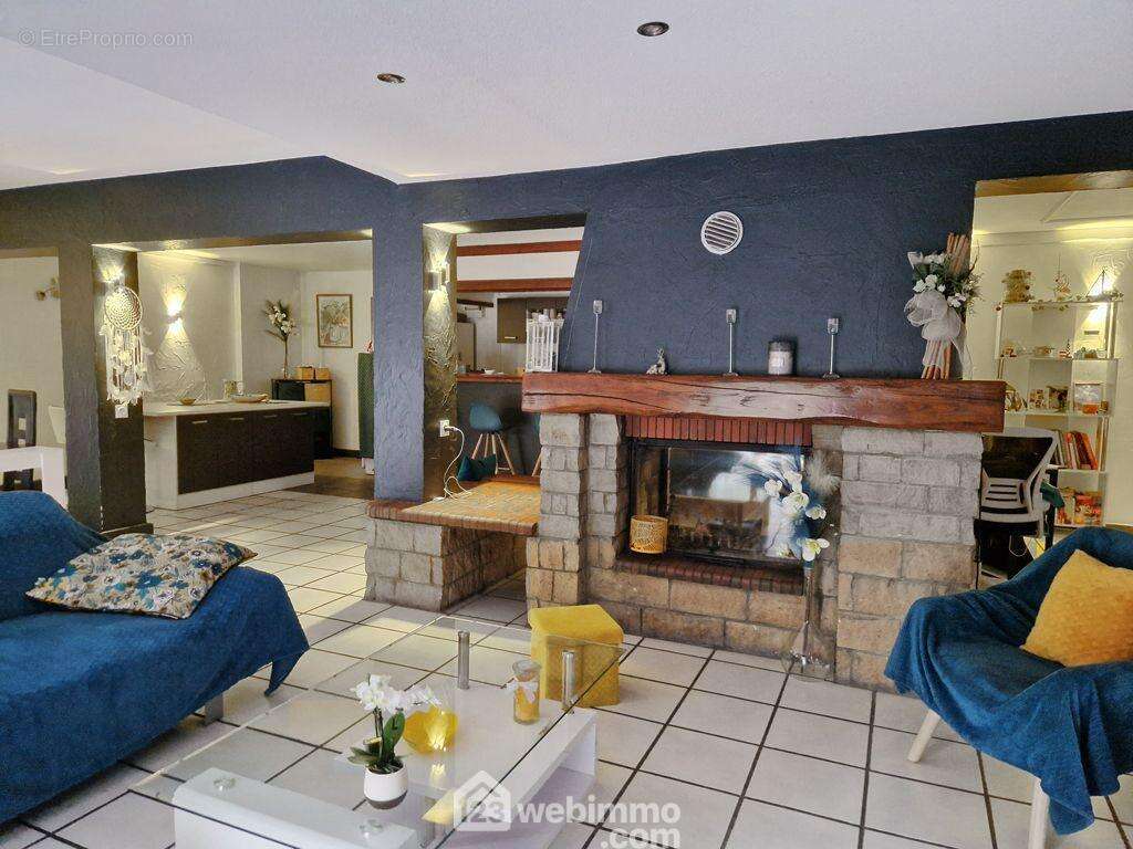 et son coin salon propose un insert à bois en chauffage d&#039;appoint. - Maison à VENTHON