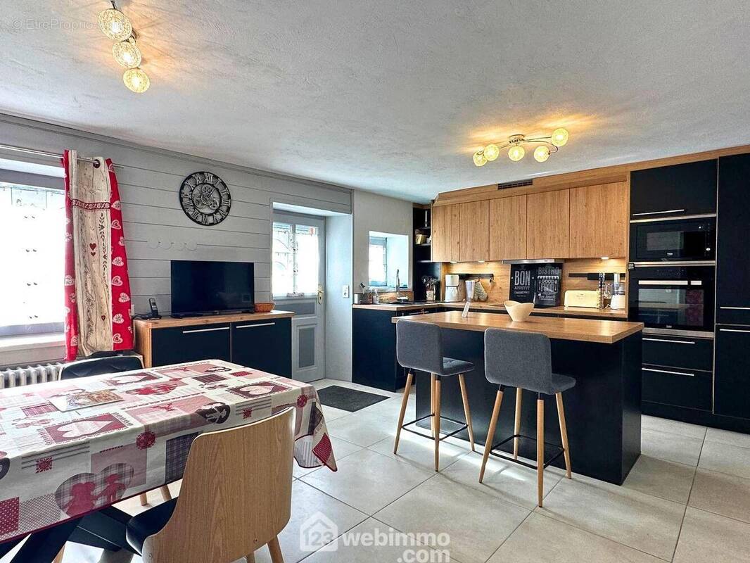 Situé en rez-de-chaussée, vous pourrez profitez de deux entrées dont une donnant sur la cuisine moderne et équipée, donnant beaucoup de charme et caractère à la pièce. - Appartement à CREST-VOLAND