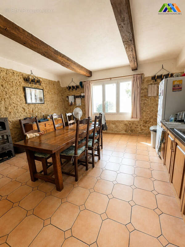 Country house kitchen dining room with beams and stone walls  