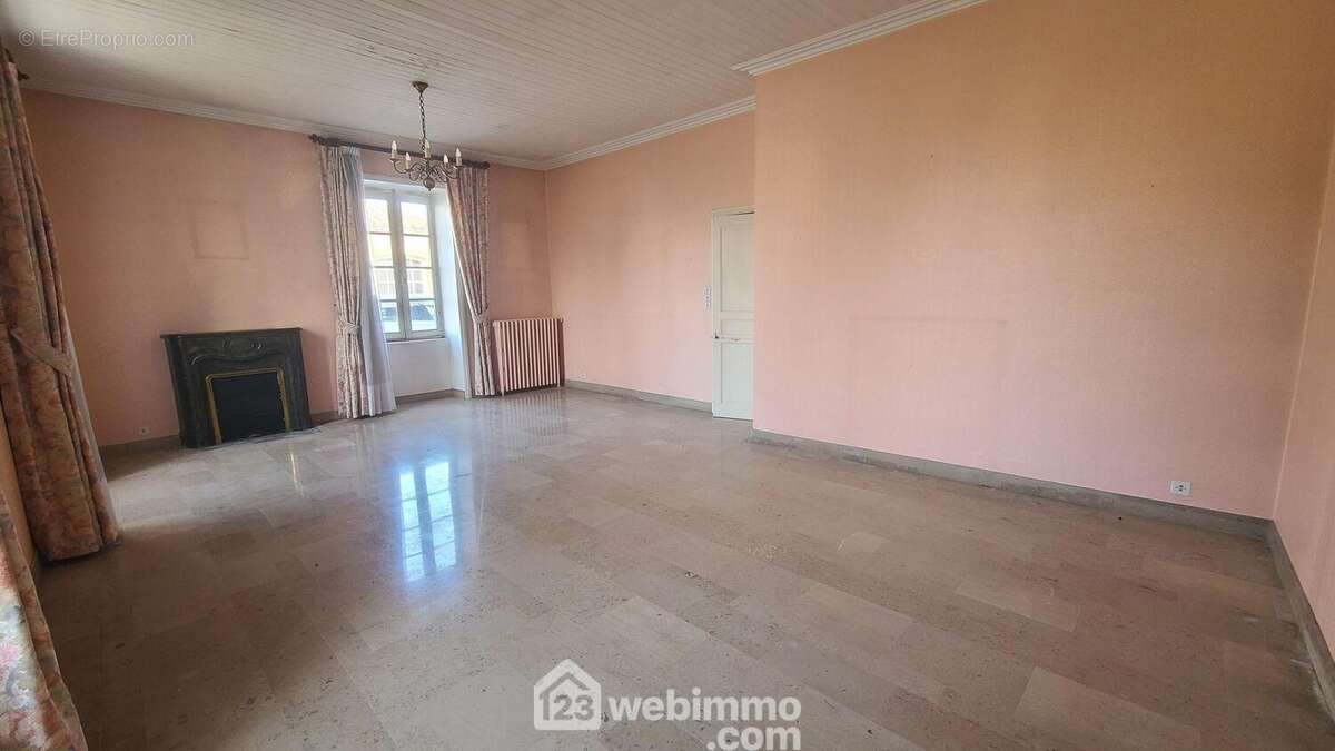 Séjour salon, belle hauteur sous plafond 2m70, cheminée et travertin au sol.