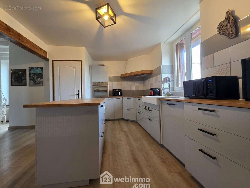 Avec îlot central, offrant de beaux plans de travail et un espace convivial pour les repas du quotidien. - Maison à REVILLON