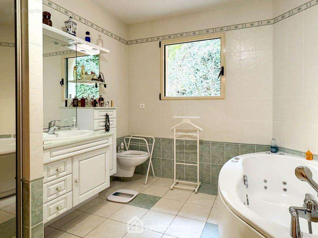 ...un dressing et une salle de bain avec douche et baignoire à balnéo. - Maison à CHOLET