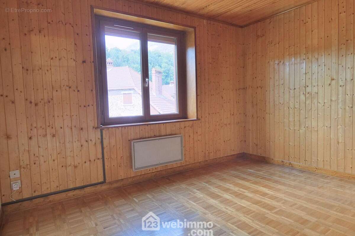 À l'étage, l'espace nuit propose deux chambres. Celle-ci de 11 m² - Maison à UGINE
