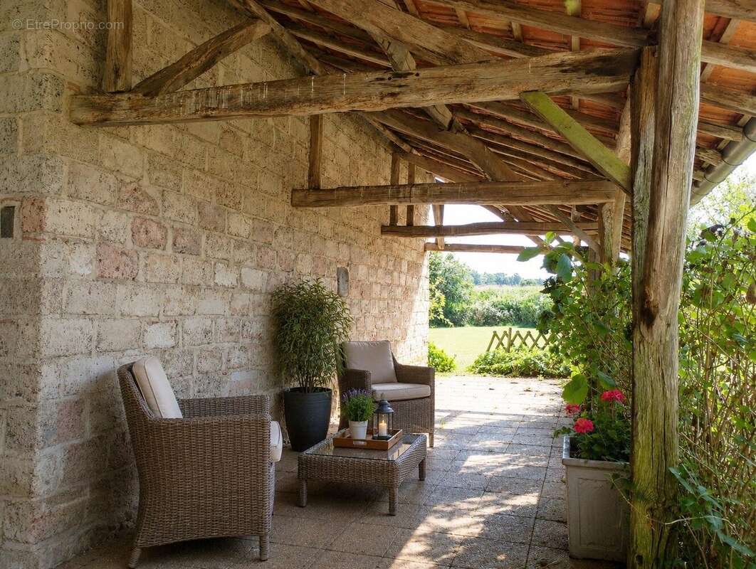 Terrasse couverte en pierre avec espace détente extérieur - Maison à TOURNAY