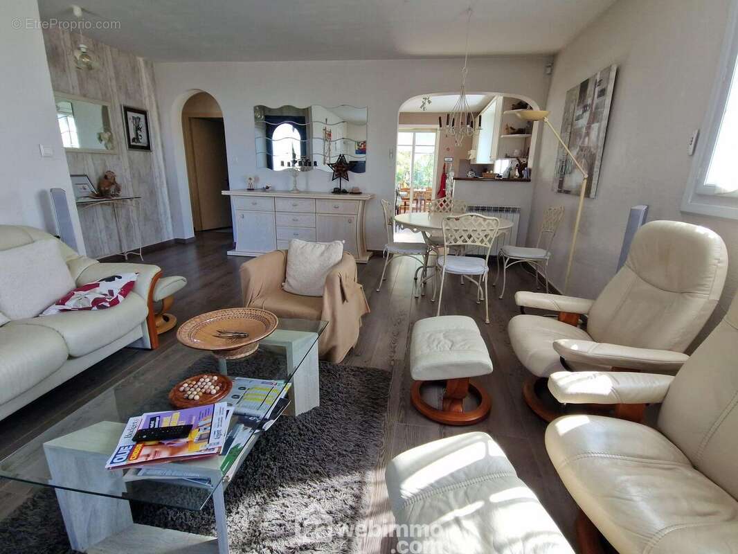 Pièce de vie avec cuisine et accès véranda au second plan - Maison à LA ROCHE-SUR-YON