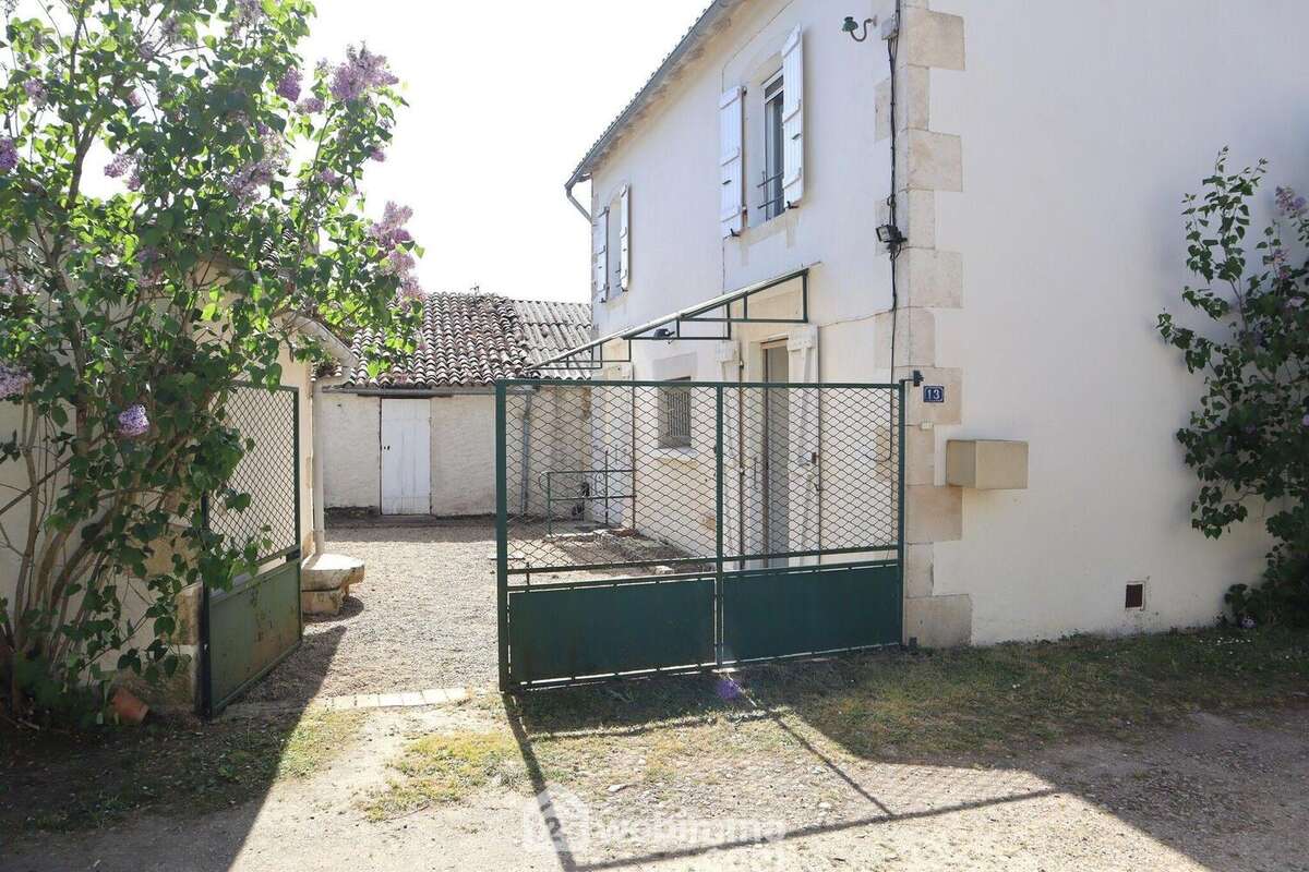 Une allée mène au portail de la cour. - Maison à CHAUVIGNY