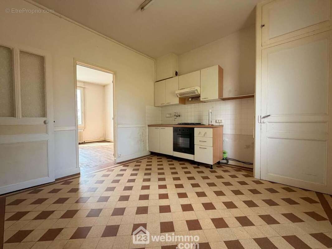 De l'autre côté de l'entrée, la cuisine de 11,3 m2, - Maison à CHATELLERAULT