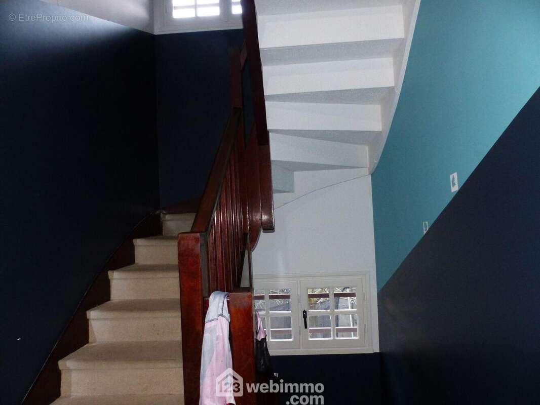 L'escalier nous dirige vers l'espace habitable de la propriété. - Maison à BIHOREL