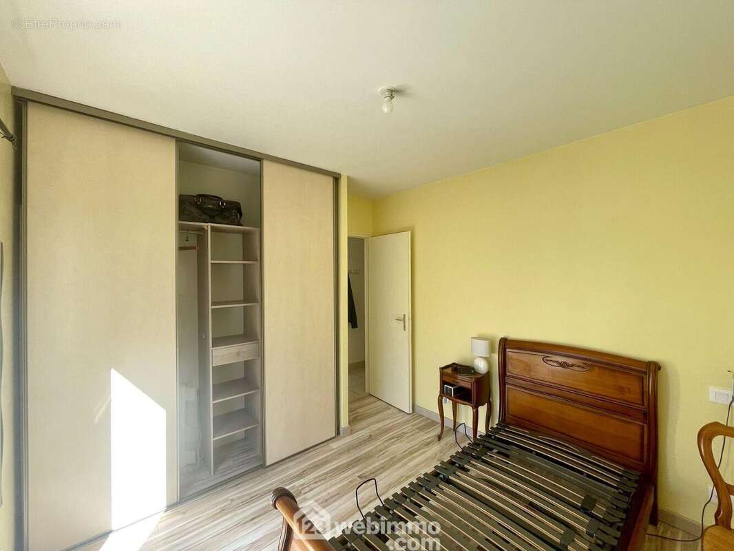 Chambre avec placard et baie vitrée.