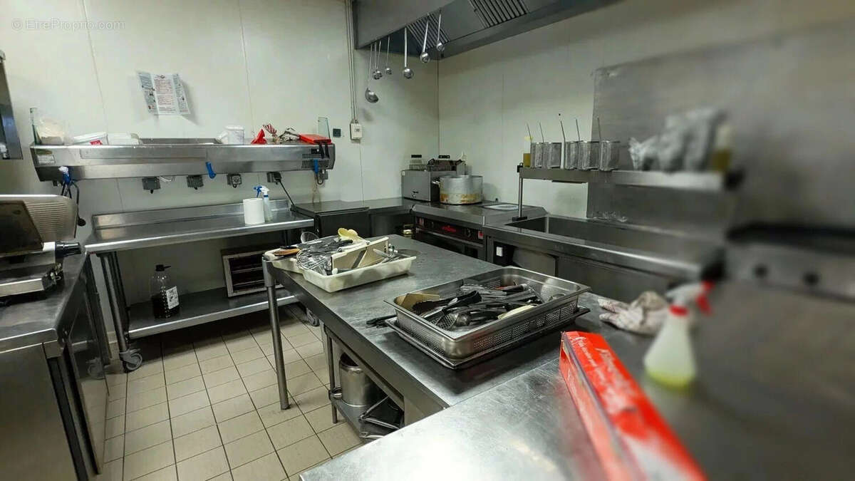 C'est une cuisine professionnelle avec des comptoirs en acier inoxydable, des équipements de cuisson, et des ustensiles. - Autre à AGEN