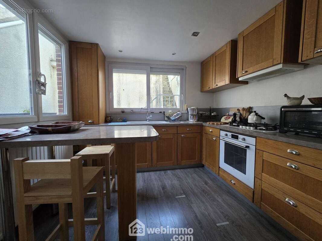 Une cuisine fonctionnelle et lumineuse, aménagée avec de nombreux rangements et un coin repas pratique pour le quotidien - Maison à SAINT-QUENTIN