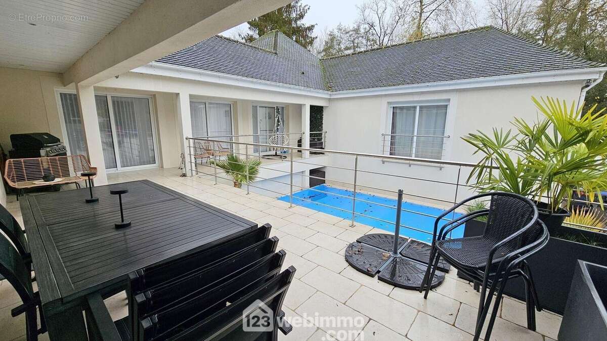 Une maison en U avec une piscine au centre et ses terrasses. - Maison à MILLY-LA-FORET
