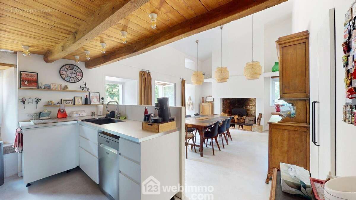 Salle à manger avec cuisine américaine et cheminée - Maison à ROSNAY