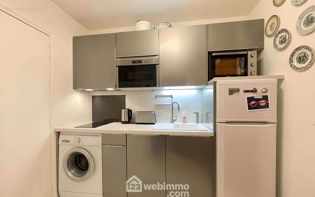 Cuisine moderne équipée avec rangements, lave-linge et électroménager complet. - Appartement à SAINTE-MAXIME
