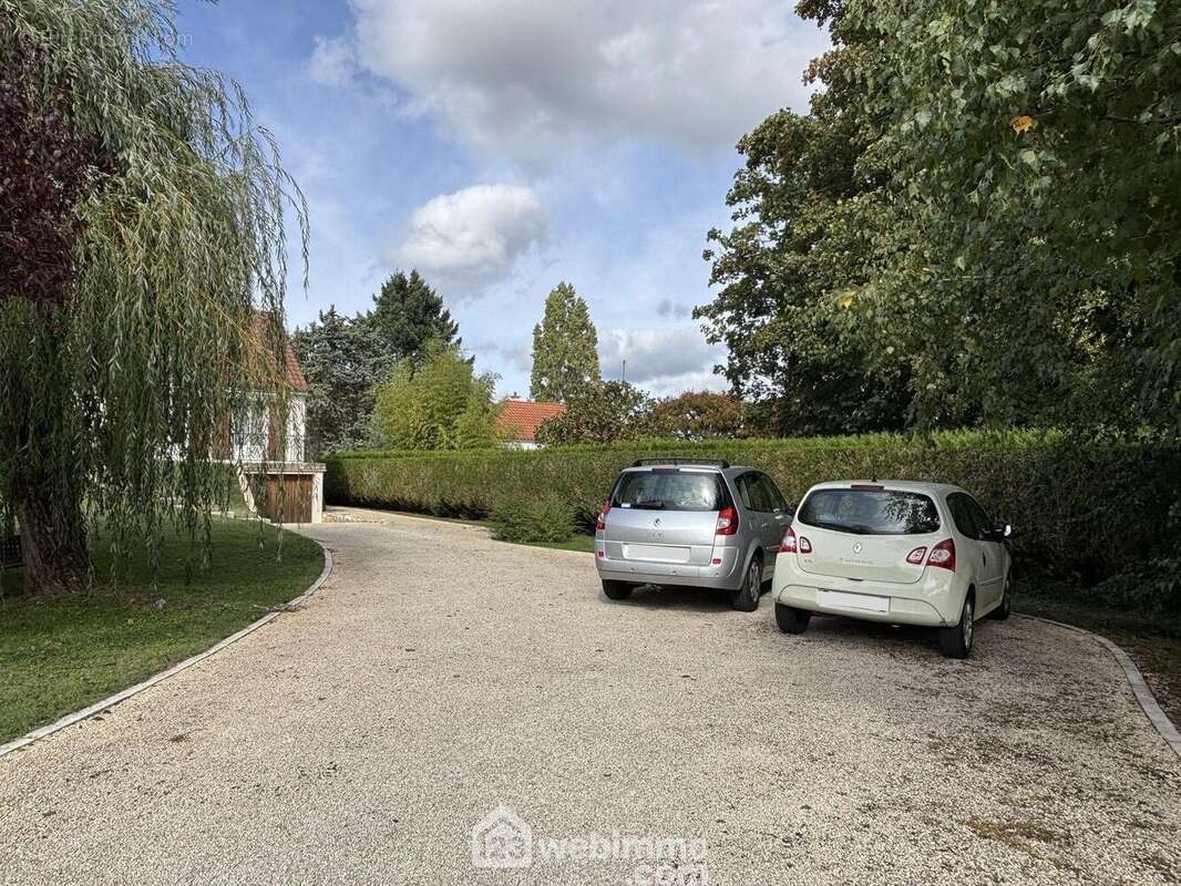 Au-delà du portail motorisé, l&#039;allée mène à une zone de stationnement, - Maison à MONTAMISE