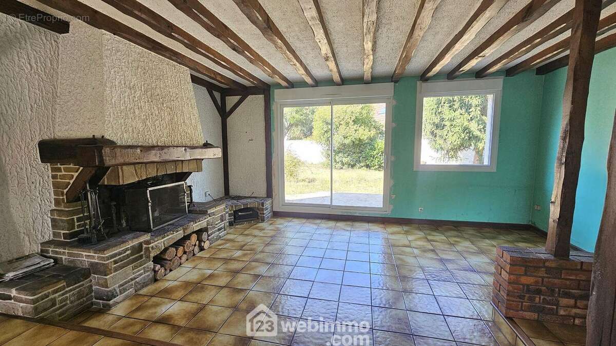 Un séjour lumineux avec sa cheminée ouverte et son accès sur la terrasse. - Maison à MILLY-LA-FORET