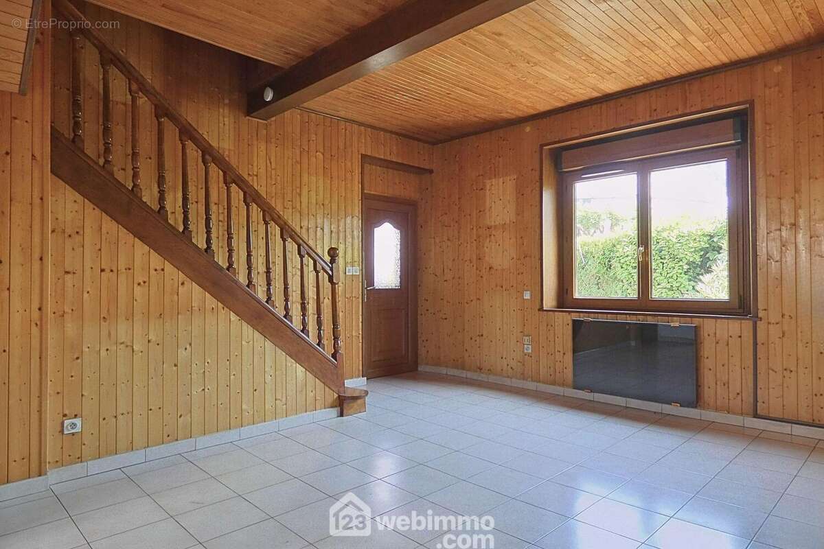 Depuis la pièce de vie, vous accédez à l'étage et à un sous-sol comprenant une cave de 29 m². - Maison à UGINE