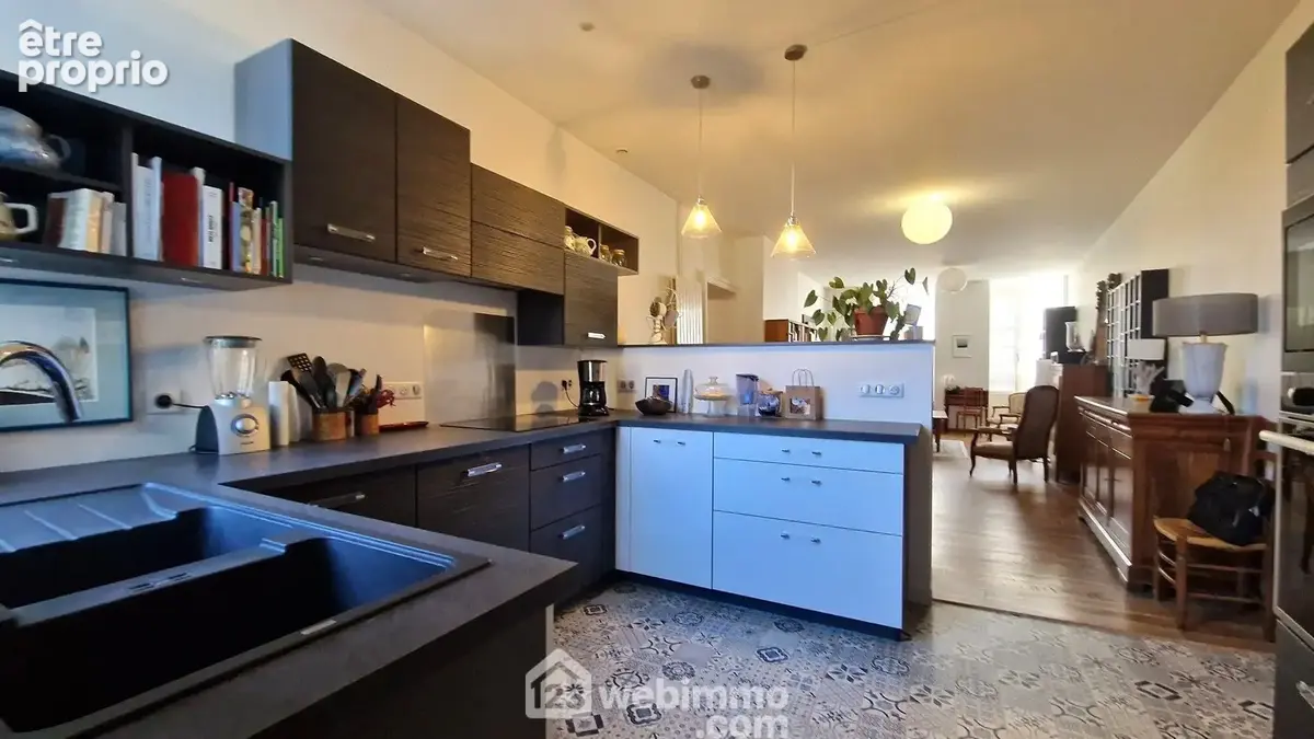 Dans son prolongement, une spacieuse cuisine ouverte vient naturellement compléter cet agréable espace de vie