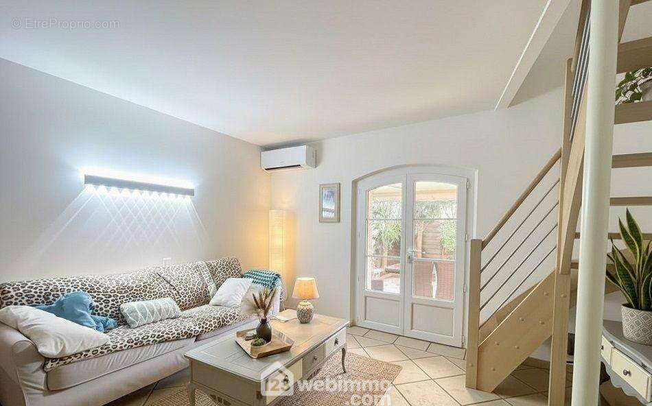 Séjour lumineux avec accès direct à la terrasse, offrant un espace convivial et chaleureux sur deux niveaux. - Appartement à SAINTE-MAXIME
