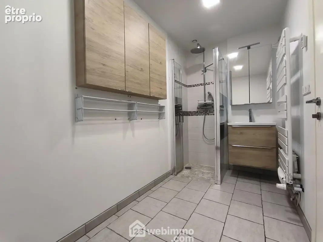 La salle d'eau de 5 m² avec douche, vasque sur meuble, WC et branchement machine à laver
