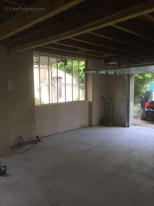 Garage de 30 m2 avec porte automatique et grenier.