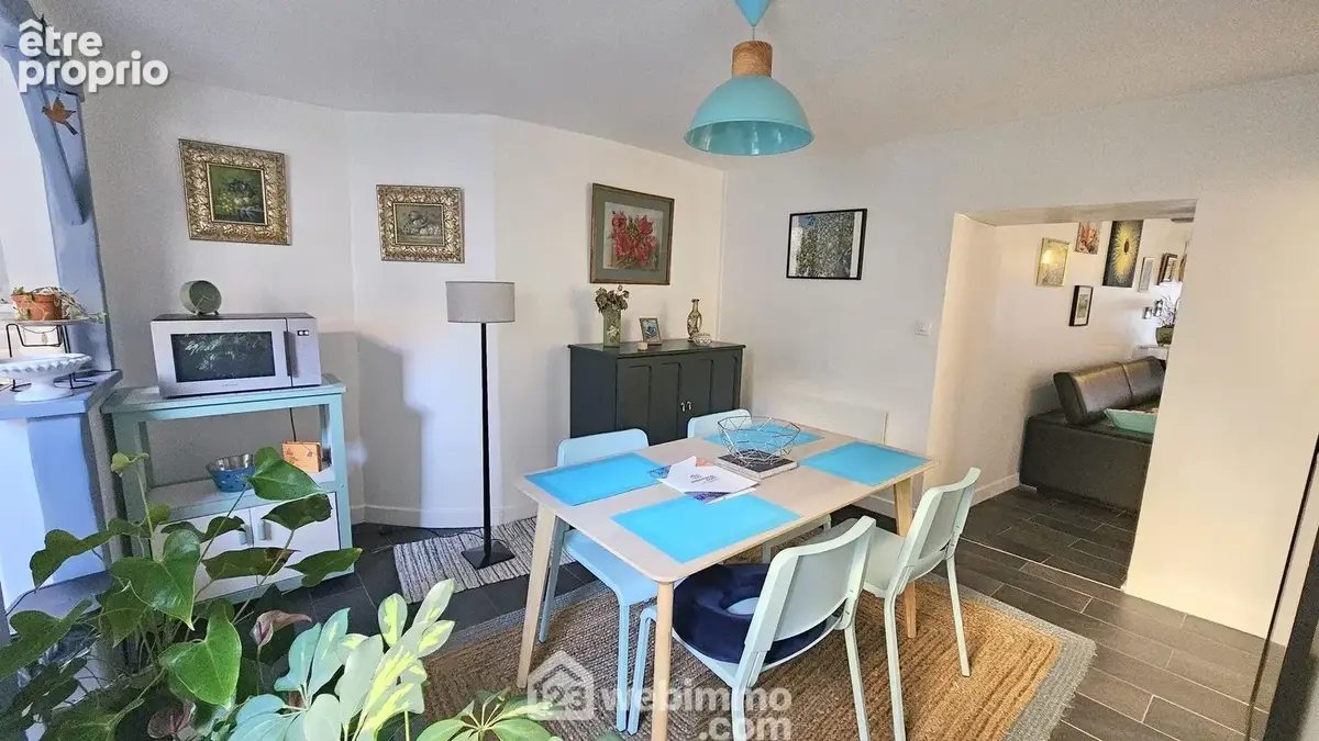 Une salle à manger avec un accès sur la cuisine.