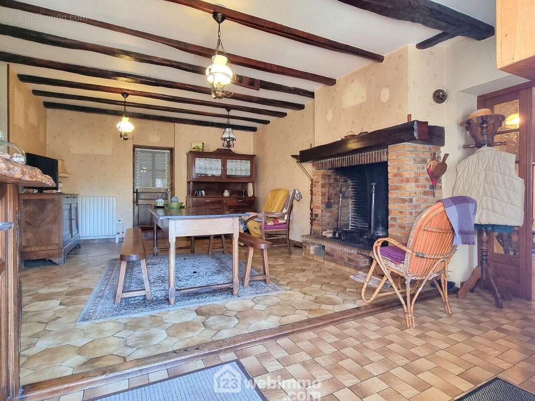 L'entrée ouvre sur une pièce d'environ 40 m2, équipée d'une cheminée, - Maison à PAMPROUX