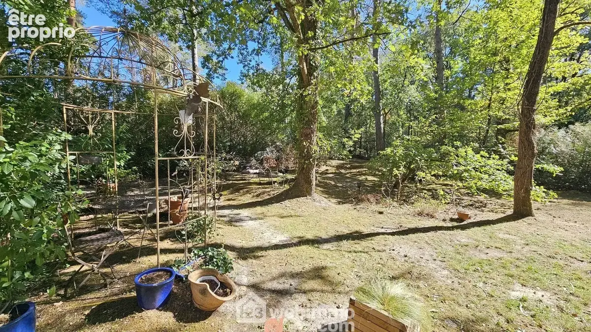 Un jardin arboré qui se fond dans le paysage forestier.