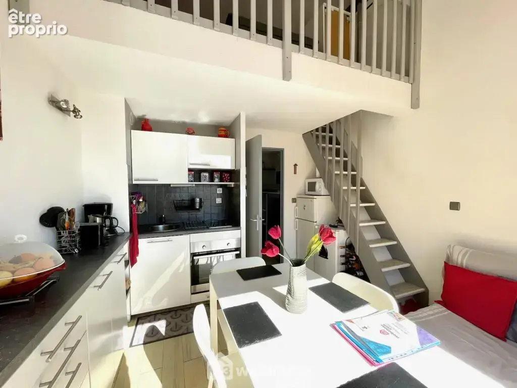 Séjour avec belle hauteur sous plafond et espace mezzanine.