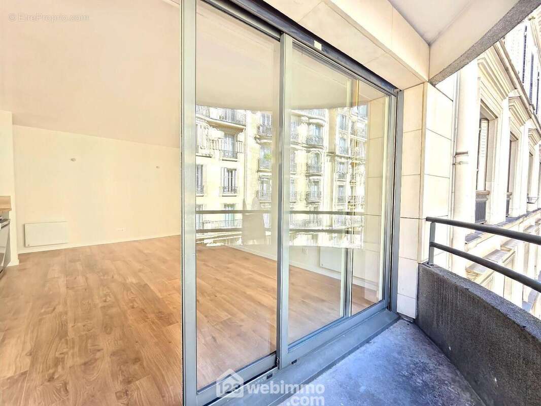 Le balcon avec sa baie vitrée et son volet électrique. - Appartement à PARIS-15E