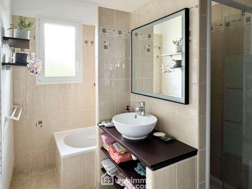 La salle de bain est équipée d'une douche, d'une baignoire et d'un placard. - Maison à MAULEON
