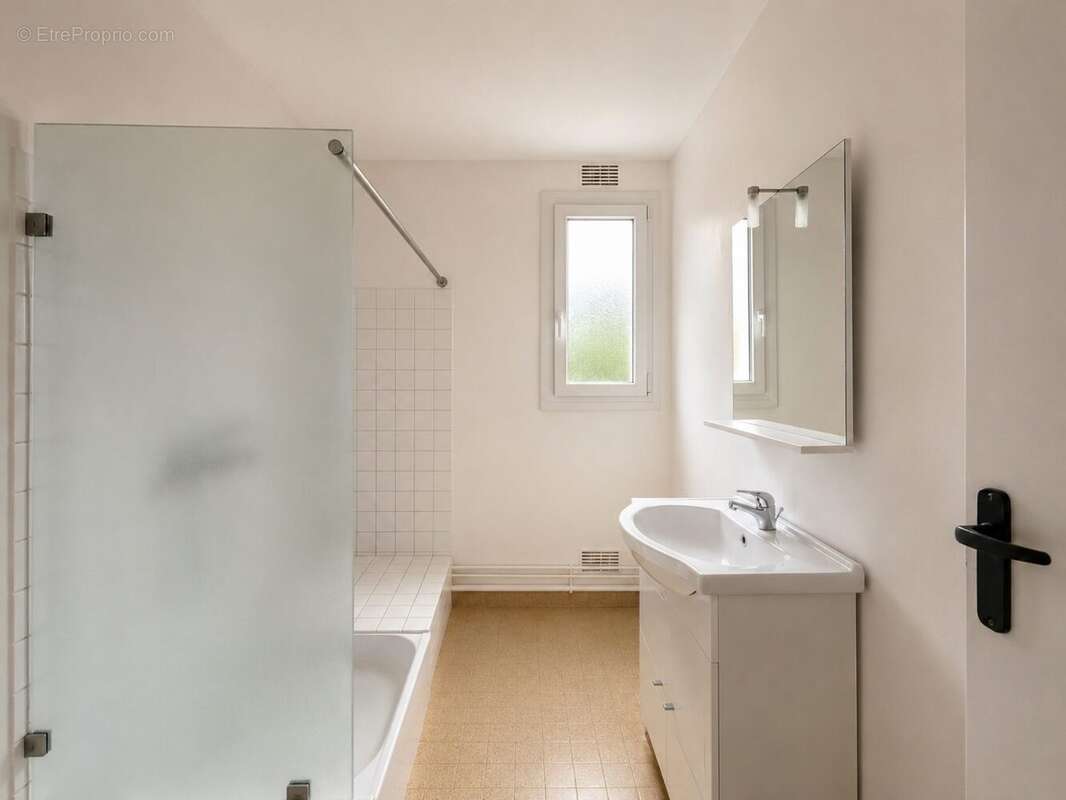 Salle d'eau rénovée et fonctionnelle Un espace pratique composé d'une douche et d'un meuble vasque. - Appartement à LOUVIERS
