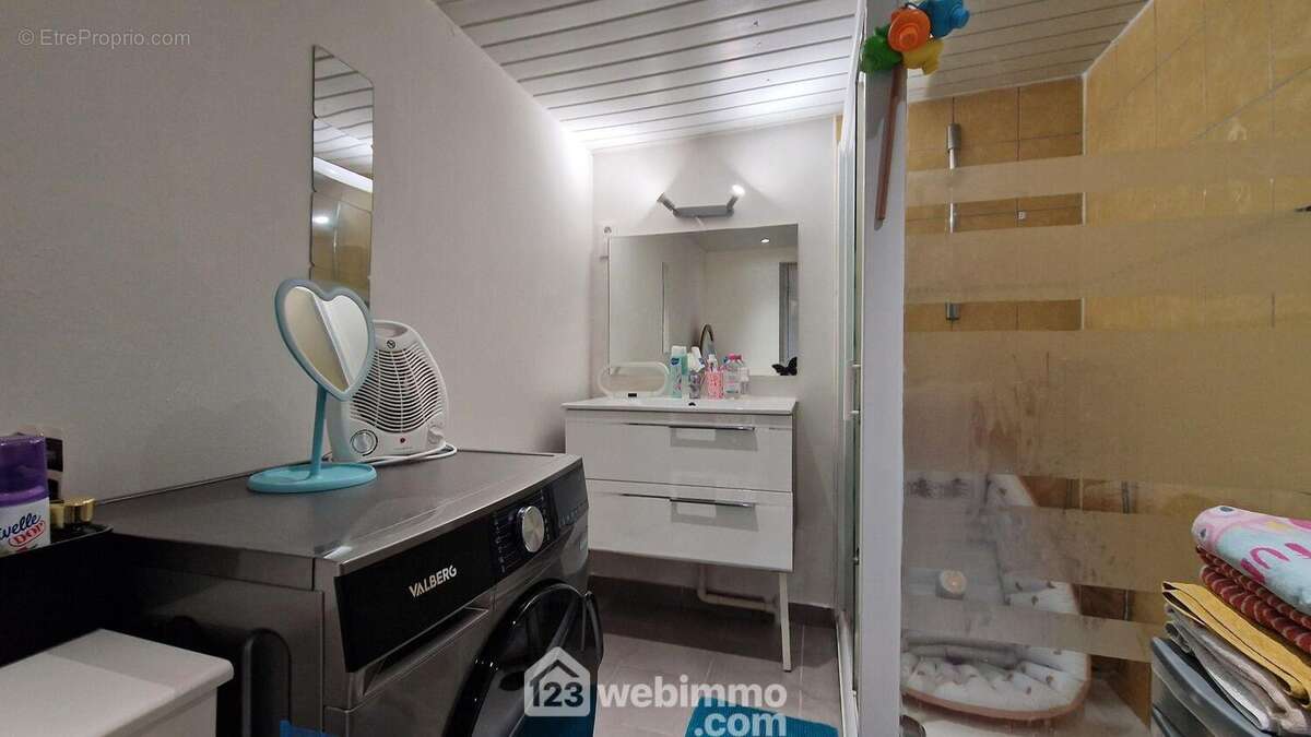 La salle de douche avec meuble vasque et radiateur sèche serviettes - Maison à EBOULEAU