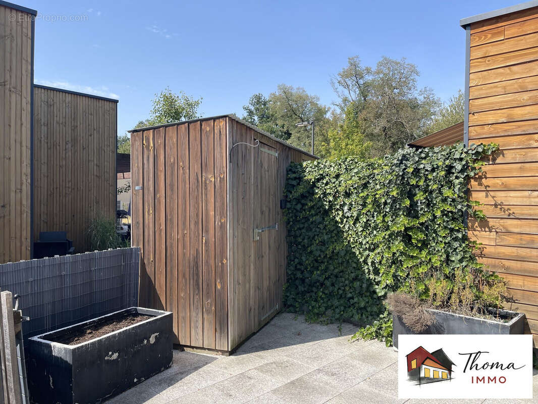 Terrasse avec cabanon et bacs à fleurs