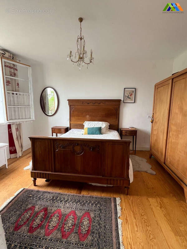 Spacious bedroom with polished wooden floors and natural light.