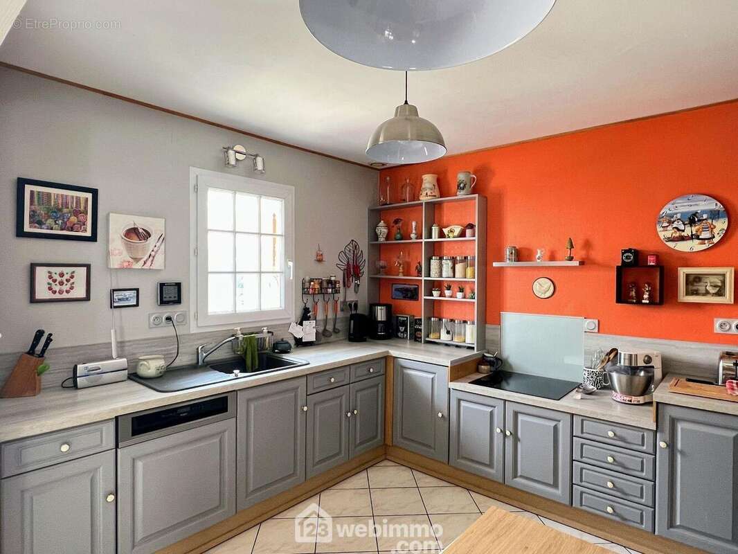 La cuisine est équipée et aménagée (plaque à induction, réfrigérateur, lave-vaisselle). - Maison à MONTREUIL-JUIGNE