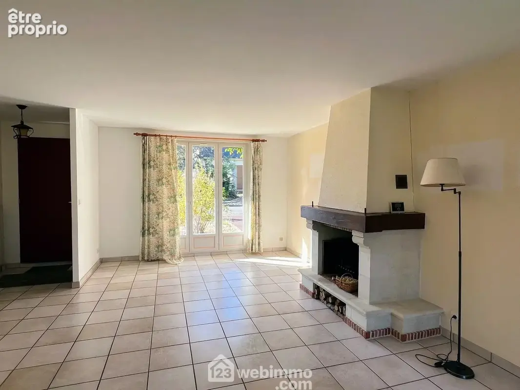 Cette grande pièce de vie de 45 m², équipée d'une cheminée, est ouverte sur le jardin et bénéficie de lumière traversante.